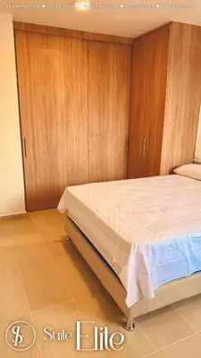 a bedroom with a large bed with wooden cabinets at Barranquilla Super Suite Elite in Barranquilla