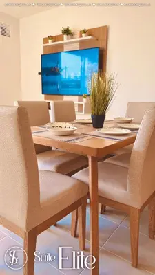 a wooden dining room table with chairs and a television at Barranquilla Super Suite Elite in Barranquilla