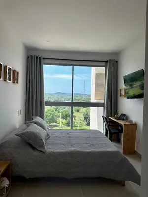 a bedroom with a bed and a large window at Baia Kristal Andrés Cartagena in Cartagena de Indias
