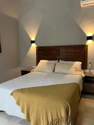 a bedroom with a large bed with two lights on it at Casa Pozo del Carretero in Cartagena de Indias