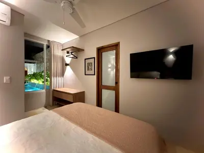 a bedroom with a bed and a television on the wall at Casa Pozo del Carretero in Cartagena de Indias