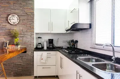 a kitchen with white cabinets and a brick wall at Vita 902 Paraíso Costero in Cartagena de Indias
