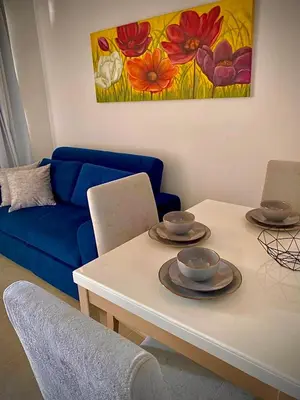a living room with a table and a blue couch at Anny Luxury Apartment - Santa Marina in Santa Marta