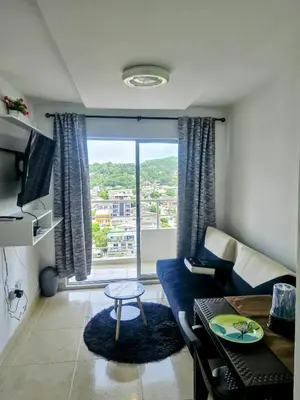 a living room with a couch and a large window at Apartamento Moderno 2H cerca Aeropuerto, Playas y Centro Historico in Cartagena de Indias