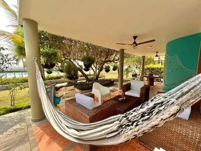 a hammock on a house with a patio at Hermosa villa frente al mar in San Silvestre
