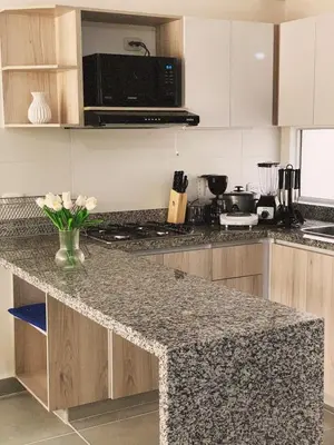 a kitchen with a granite counter top with a microwave at Amazing apartment cerca the beach Manzanillo Sector in Cartagena de Indias