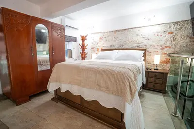 a bedroom with a large bed and a stone wall at Alma Blanca - Colonial Loft in the Walled City in Cartagena de Indias