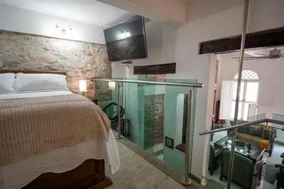 a bedroom with a bed and a glass enclosure at Alma Blanca - Colonial Loft in the Walled City in Cartagena de Indias