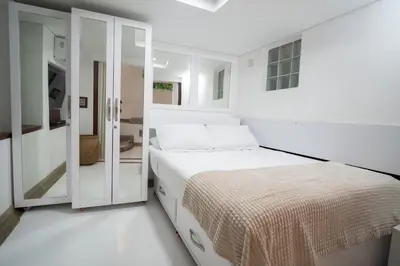 a white bedroom with a bed and a sliding glass door at Alma Blanca - Colonial Loft in the Walled City in Cartagena de Indias