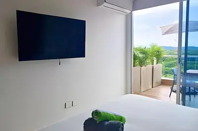 a bedroom with a bed with a flat screen tv on the wall at Ultimo piso, amplia terraza y vista impresionante! in Los Arrayanes
