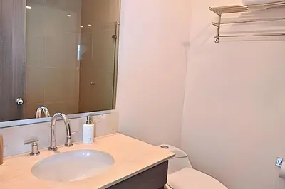 a bathroom with a sink and a toilet and a mirror at Luxury Escape: Sea, Comfort & Style in Cartagena de Indias