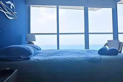 a blue bedroom with a bed and a window at Luxury Escape: Sea, Comfort & Style in Cartagena de Indias