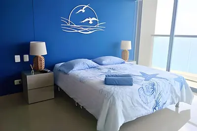 a blue bedroom with a bed with a blue wall at Luxury Escape: Sea, Comfort & Style in Cartagena de Indias