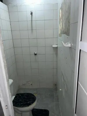 a bathroom with a toilet and a tiled floor at Hoteles & Restaurantes Doña Nerta in Cartagena de Indias
