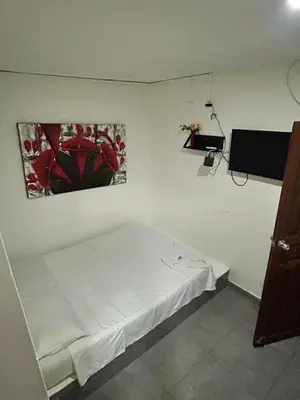 a room with a white bed with a picture on the wall at Hoteles & Restaurantes Doña Nerta in Cartagena de Indias