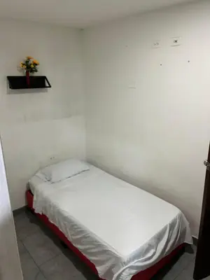 a small bed in a room with a white wall at Hoteles & Restaurantes Doña Nerta in Cartagena de Indias