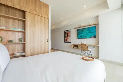 a bedroom with a white bed and a tv on the wall at CB1515 | Lujosa suite con vista al mar y balcón in Cartagena de Indias