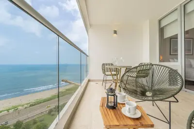 a room with a table and chairs and a view of the ocean at CB1515 | Lujosa suite con vista al mar y balcón in Cartagena de Indias