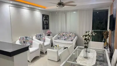 a living room with white chairs and a table at Lindo Apartamento en la Boquilla BBB 4 pax in Cartagena de Indias