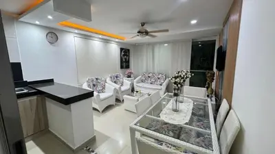 a living room with white chairs and a table at Lindo Apartamento en la Boquilla BBB 4 pax in Cartagena de Indias