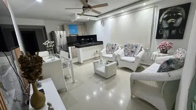 a living room with white furniture and a kitchen at Lindo Apartamento en la Boquilla BBB 4 pax in Cartagena de Indias