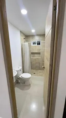 a white bathroom with a toilet and a shower at Lindo Apartamento en la Boquilla BBB 4 pax in Cartagena de Indias