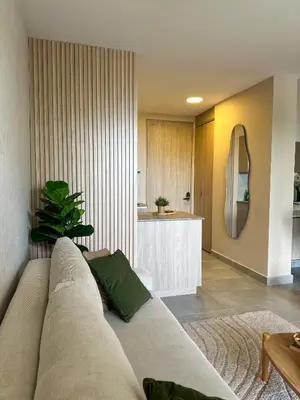 a living room with a couch and a kitchen at Living Sunset by Santa Marina in Santa Marta