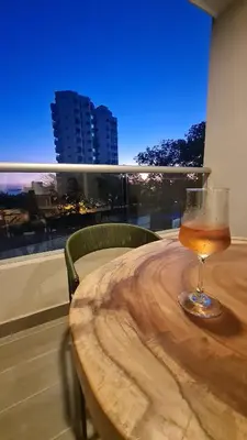 a wine glass sitting on top of a wooden table at Living Sunset by Santa Marina in Santa Marta