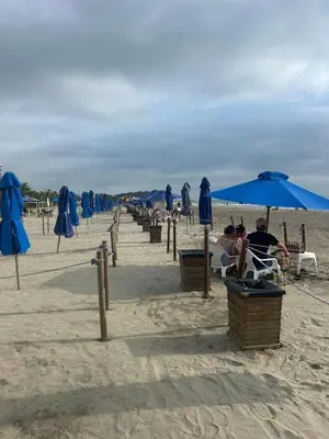a group of people sitting under umbrellas on the beach at Cartagena 2 Hab con Terraza Privada Playa 12 min Parking in Manzanillo del Mar