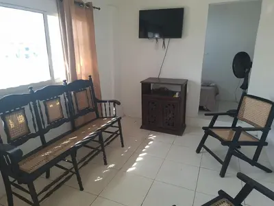 a living room with two benches and a television at Alojamiento Marbella Turismo in Cartagena de Indias