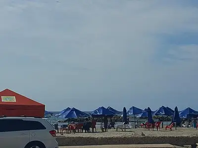 a group of blue umbrellas and chairs on a beach at Alojamiento Marbella Turismo in Cartagena de Indias