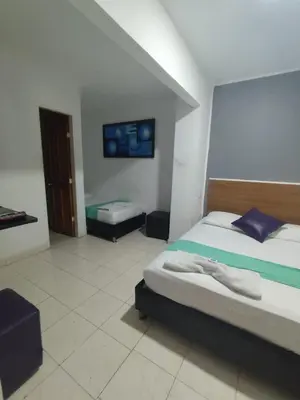 a bedroom with two beds in a room at Hotel Madeleine Norte in Barranquilla