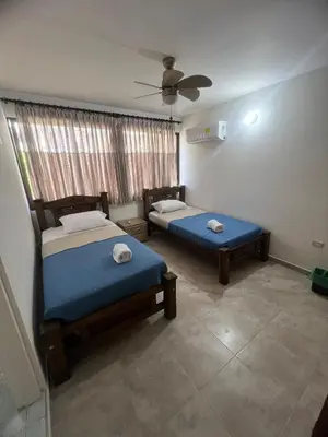 a bedroom with two beds and a ceiling fan at Casa Crespo Caribe Cartagena in Cartagena de Indias