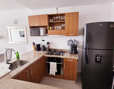 a kitchen with a black refrigerator and a sink at Ikigai frente al mar con piscina infinita y Gym in Cartagena de Indias