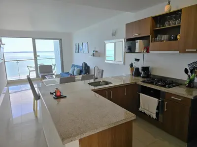 a kitchen with a counter with a sink and a stove at Ikigai frente al mar con piscina infinita y Gym in Cartagena de Indias