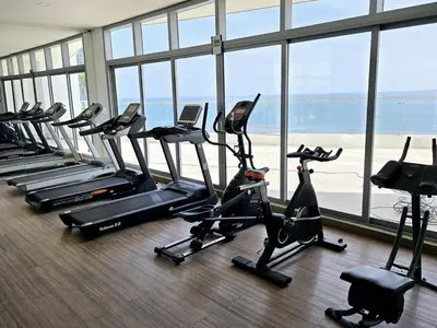 a gym with a row of treadmills and elliptical machines at Ikigai frente al mar con piscina infinita y Gym in Cartagena de Indias