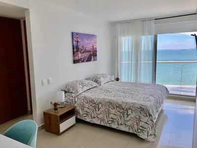 a bedroom with a bed with a view of the ocean at Ikigai frente al mar con piscina infinita y Gym in Cartagena de Indias