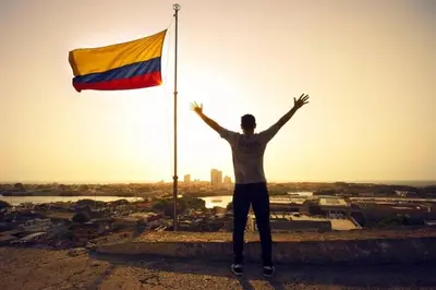 a man standing on a ledge next to a flag at City Tour por Cartagena con entradas in Cartagena de Indias