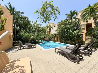 a swimming pool with lounge chairs next to a building at Bohemia home Getsemaní in Cartagena de Indias