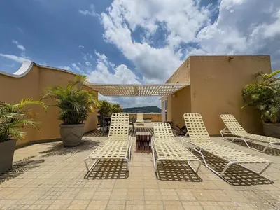 a patio with white chairs and a table and umbrella at Bohemia home Getsemaní in Cartagena de Indias