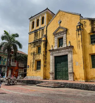 an old yellow building with a green door at Bohemia home Getsemaní in Cartagena de Indias