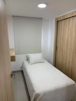 a small bedroom with a bed and a mirror at Apartamento moderno para rentar por Días - Nuevo in Barranquilla