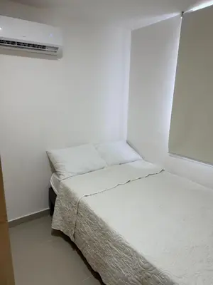 a white room with a bed and a window at Apartamento moderno para rentar por Días - Nuevo in Barranquilla