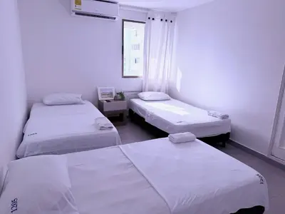a room with three beds and a window at Ocean view apartment in a great location in Cartagena de Indias