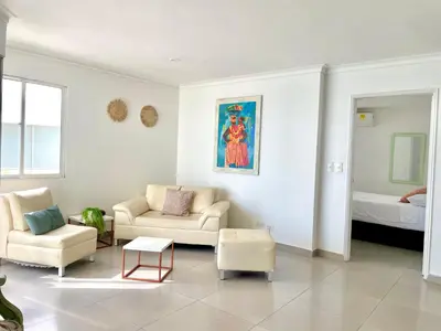 a living room with two chairs and a couch and a bed at Ocean view apartment in a great location in Cartagena de Indias