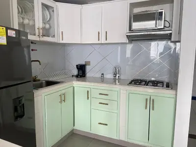 a kitchen with white cabinets and a sink and a microwave at Ocean view apartment in a great location in Cartagena de Indias