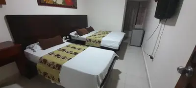 a room with two beds and a television in it at Hotel Paseo Colon in Barranquilla