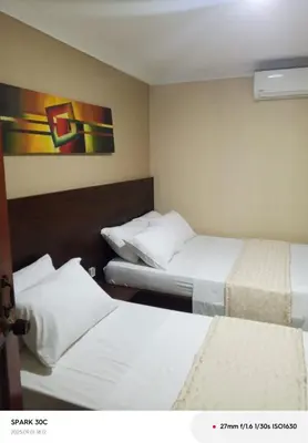 a hotel room with two beds and a painting on the wall at Hotel Paseo Colon in Barranquilla