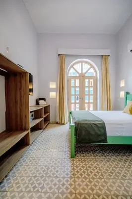 a bedroom with a bed and a large window at La Dominica Hotel Boutique in Cartagena de Indias