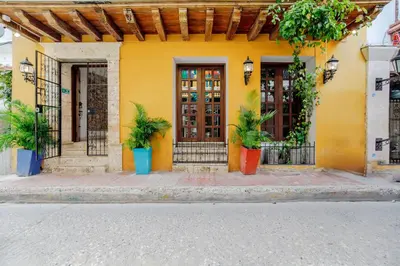 a yellow house with plants in front of it at La Dominica Hotel Boutique in Cartagena de Indias